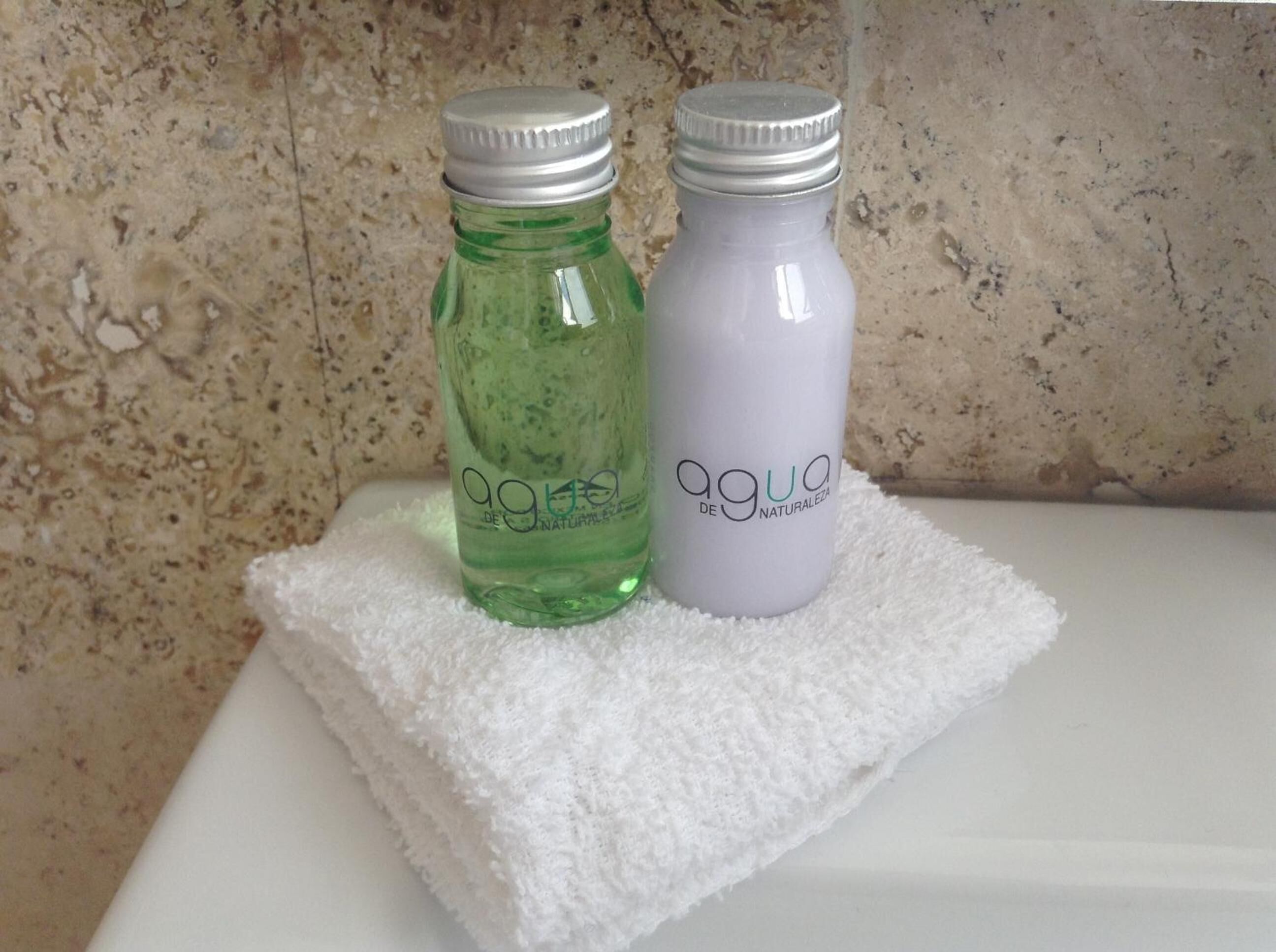 Zwei Flaschen 'agua de jengibre' auf einem weißen Handtuch.
