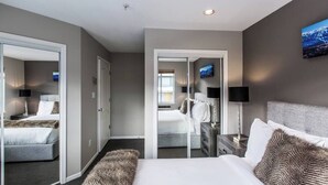 Een hotelkamer met een bed, nachtkastjes, een spiegel en een televisie.