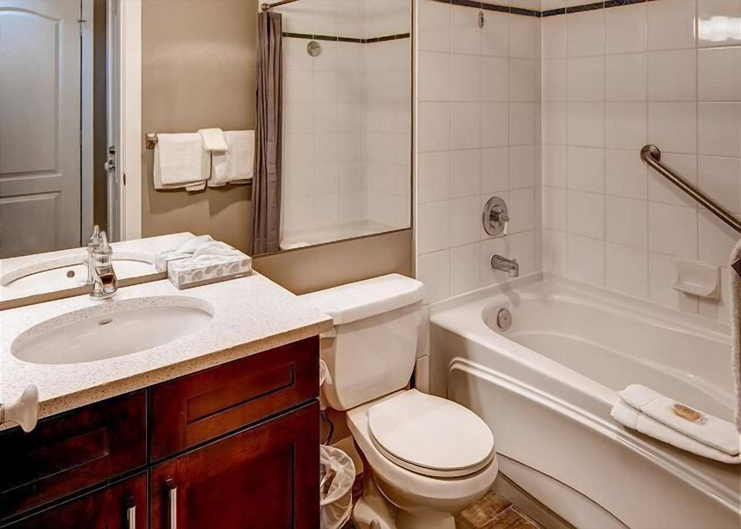 Een badkamer met wastafel, toilet en bad.