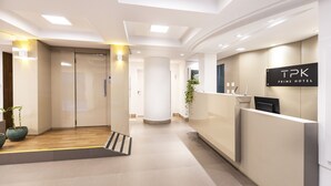A hotel reception area with a reception desk, a potted plant, and a sign that reads "TPK Prime Hotel". - Tropikalya Prime Hotel (Balneário Camboriú)