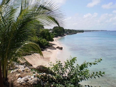 Una playa cerca, arena blanca, sillas reclinables de playa, sombrillas