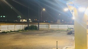 A nighttime view of an Executive Inn sign, a white picket fence, and a well-lit building structure. - Executive Inn (Robstown)