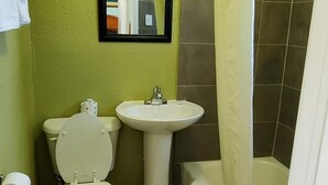 Une salle de bain avec des toilettes, un lavabo et une baignoire.