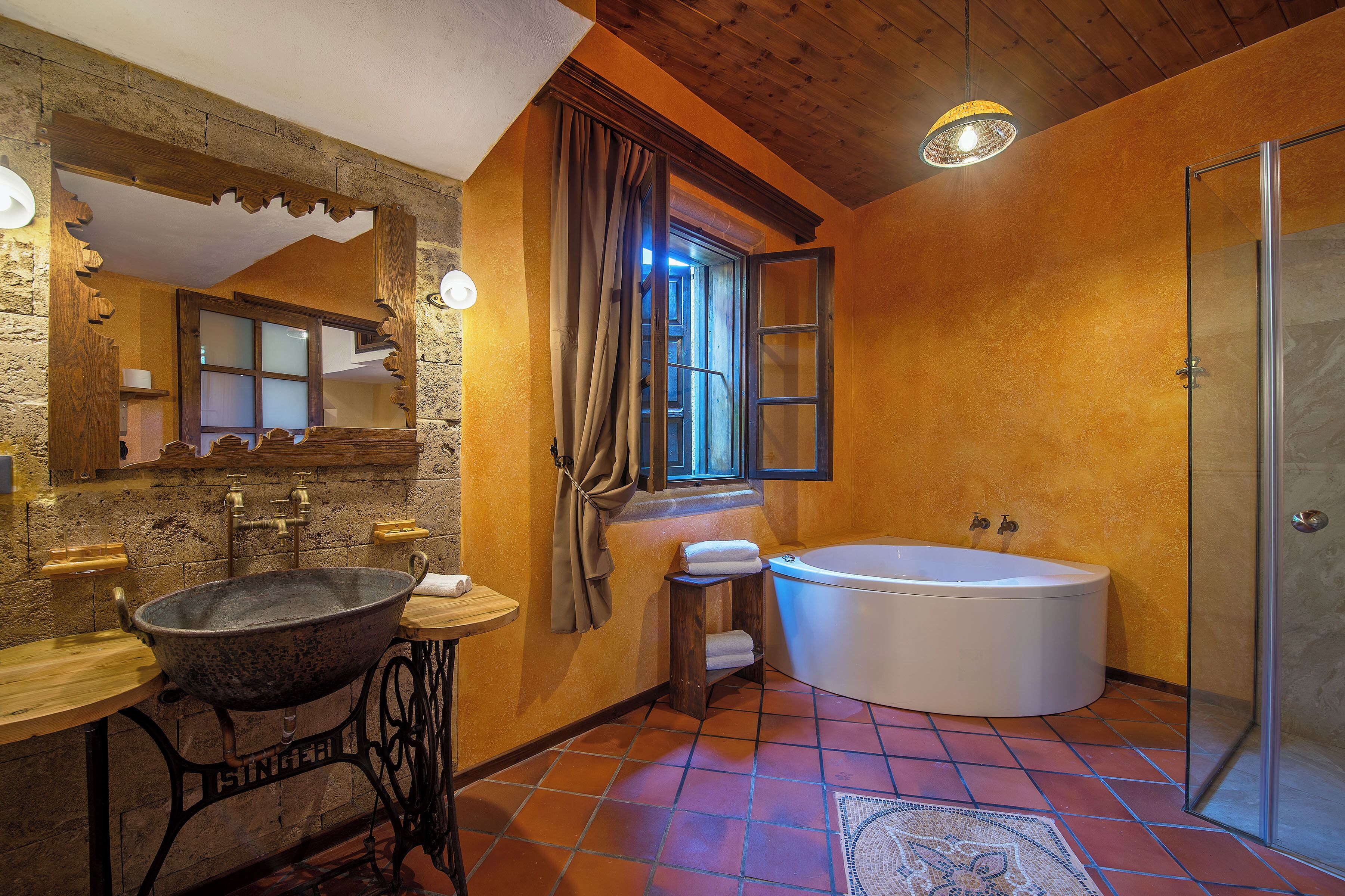 Un baño con lavamanos de piedra, una bañera y una cabina de ducha de vidrio.
