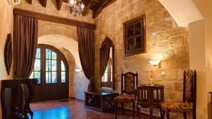 Una habitación rústica con paredes de piedra, muebles de madera y piso de baldosas.