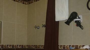 Un baño con ducha, inodoro y perchero para toallas.