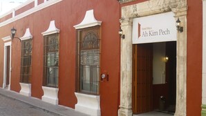 Un edificio rojo con un letrero que dice Hotel Maya Ah Kim Pech.