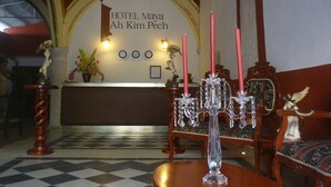 Un área de recepción con suelo a cuadros, un mostrador de recepción y una araña.