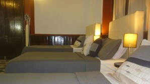 Una habitación de hotel con dos camas, cada una con una almohada y una lámpara de noche.