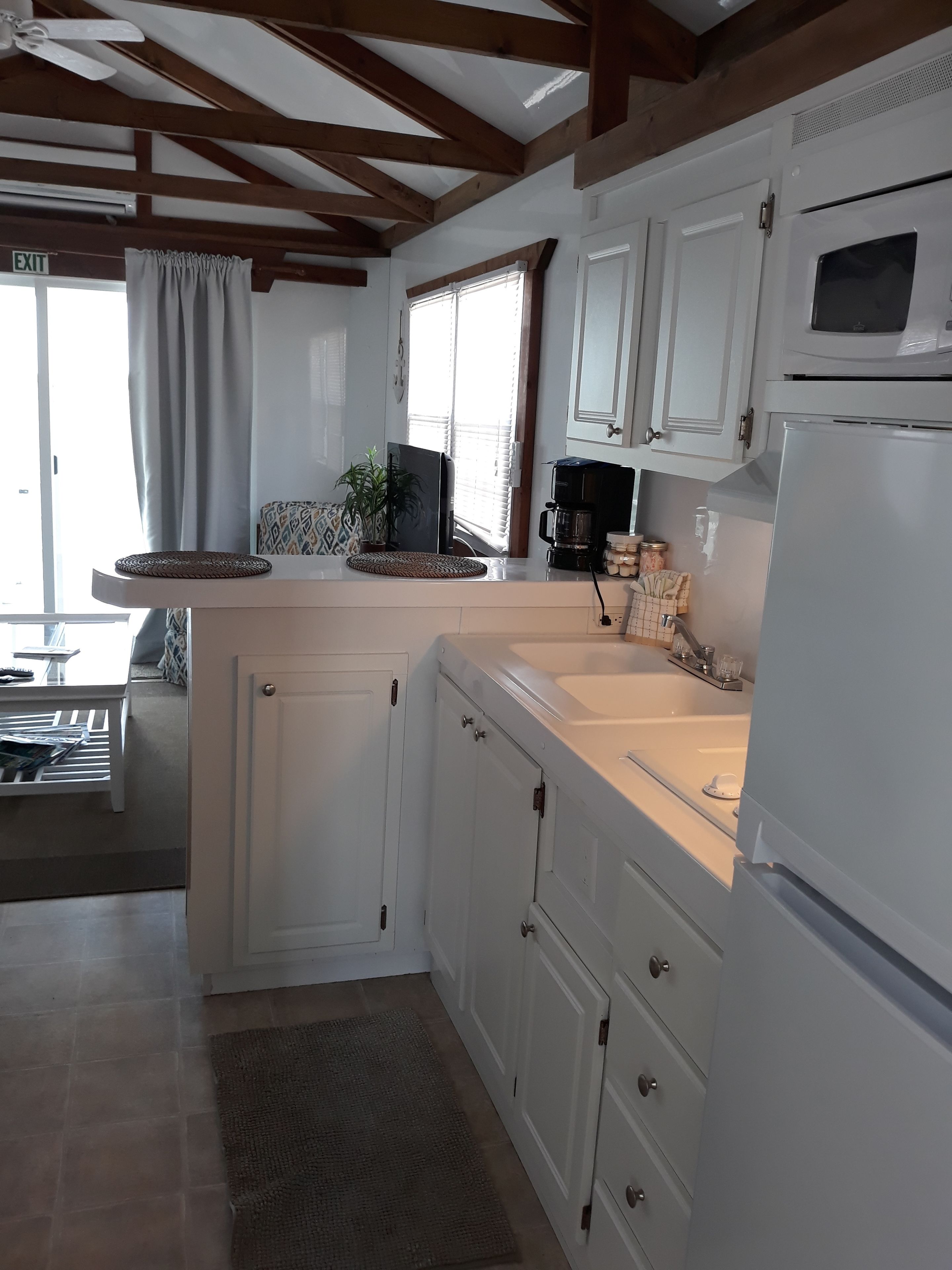 A kitchen with white cabinets, a built-in oven, and a coffee maker.