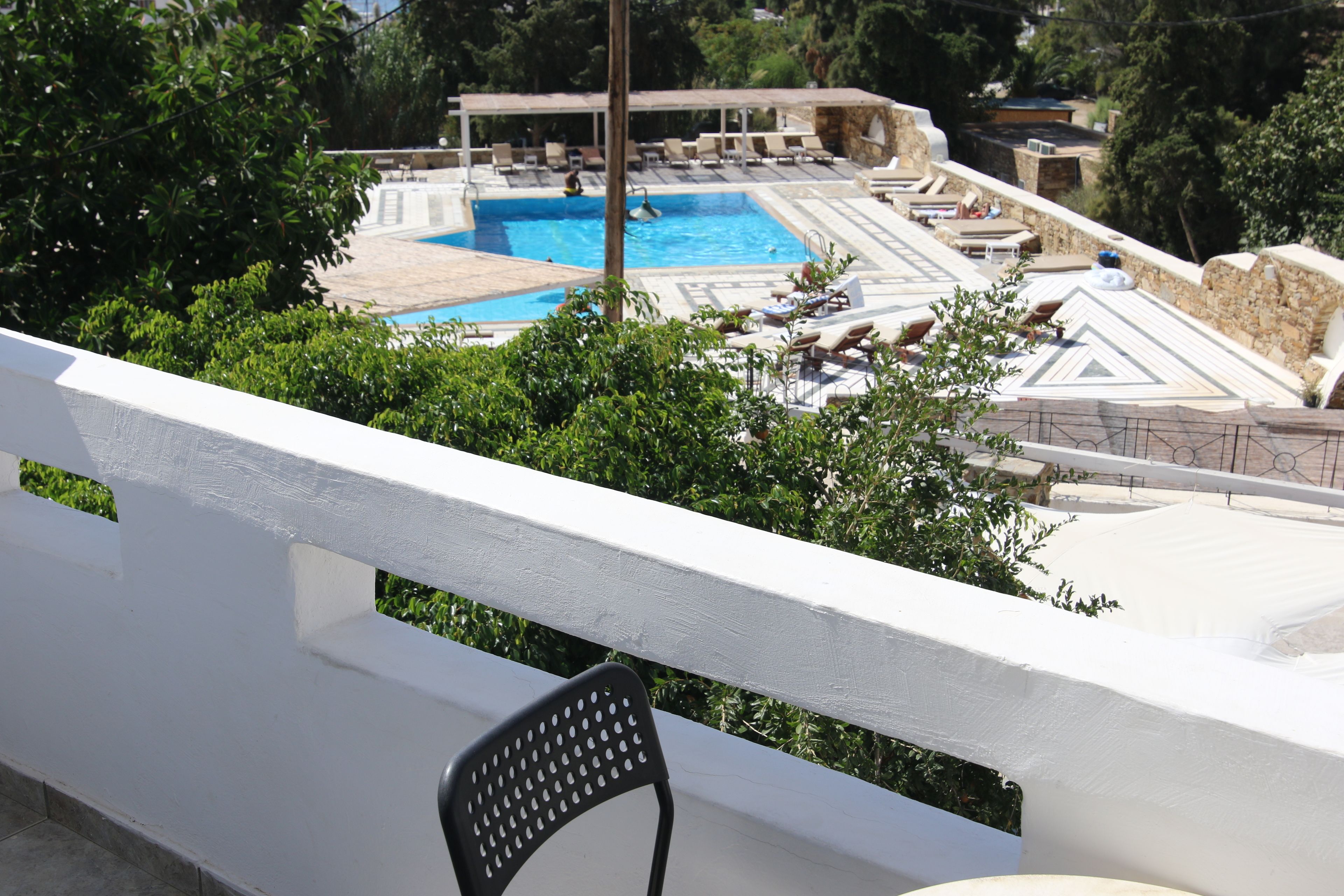 A pool area with lounge chairs and a view of the surrounding landscape.