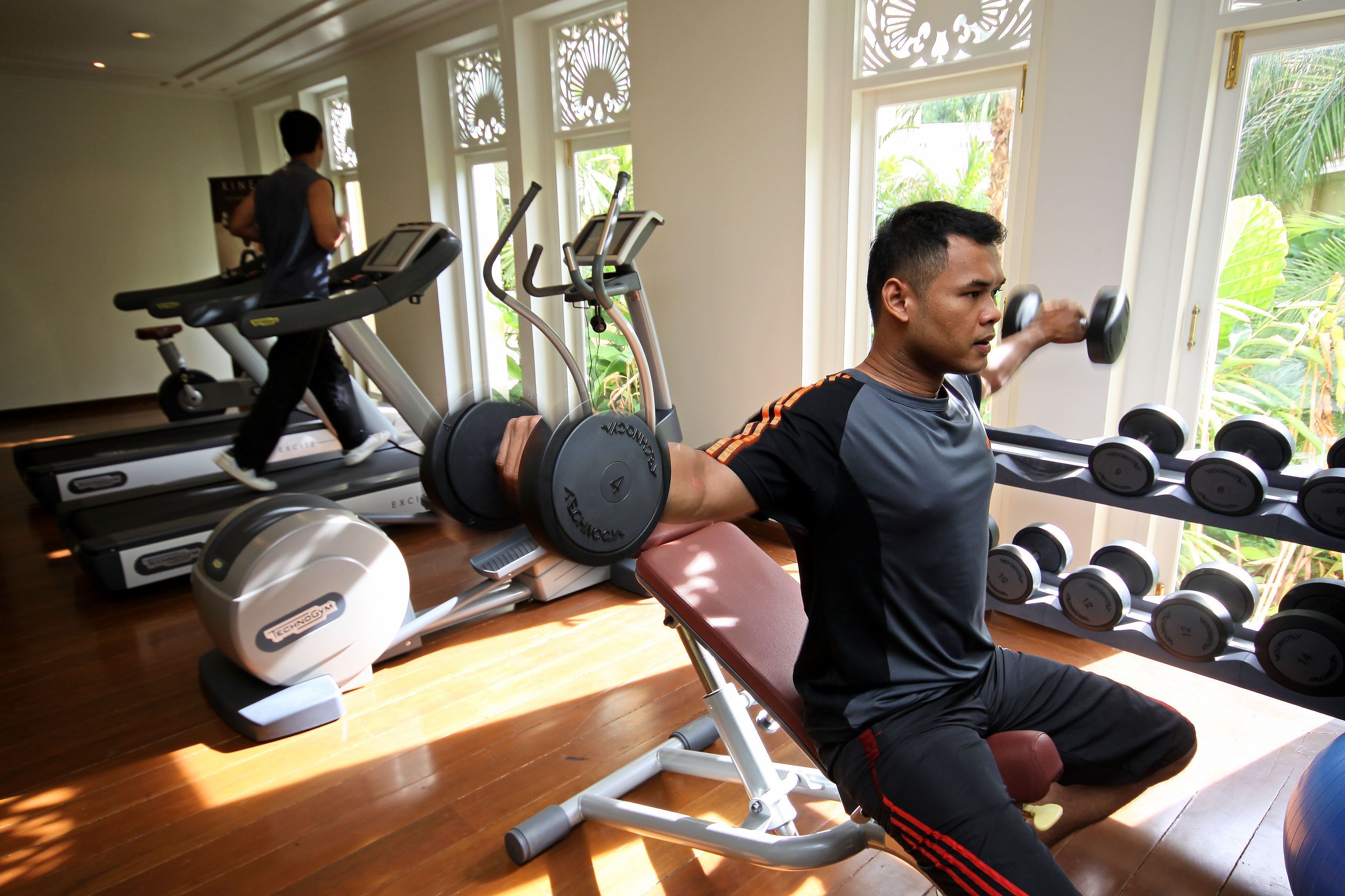 Ein Fitnessstudio mit Laufbändern, Gewichten und Trainingsgeräten.
