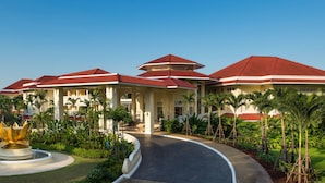 A resort with multiple buildings, a central fountain, and lush greenery.