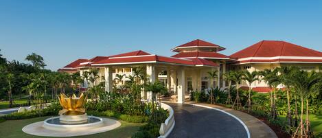 A resort with multiple buildings, a central fountain, and lush greenery.