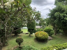 Un jardín exuberante con diferentes árboles, arbustos y un césped bien cuidado.