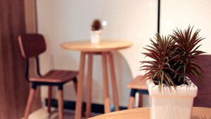 Una mesa redonda de madera con una planta en maceta al frente.