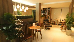 Un interior moderno con una zona de bar, asientos y plantas en macetas.