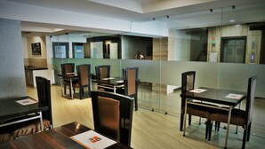 A modern conference room with glass partitions, wooden tables, and chairs. - Ginger Ahmedabad, Satellite (Ahmedabad)