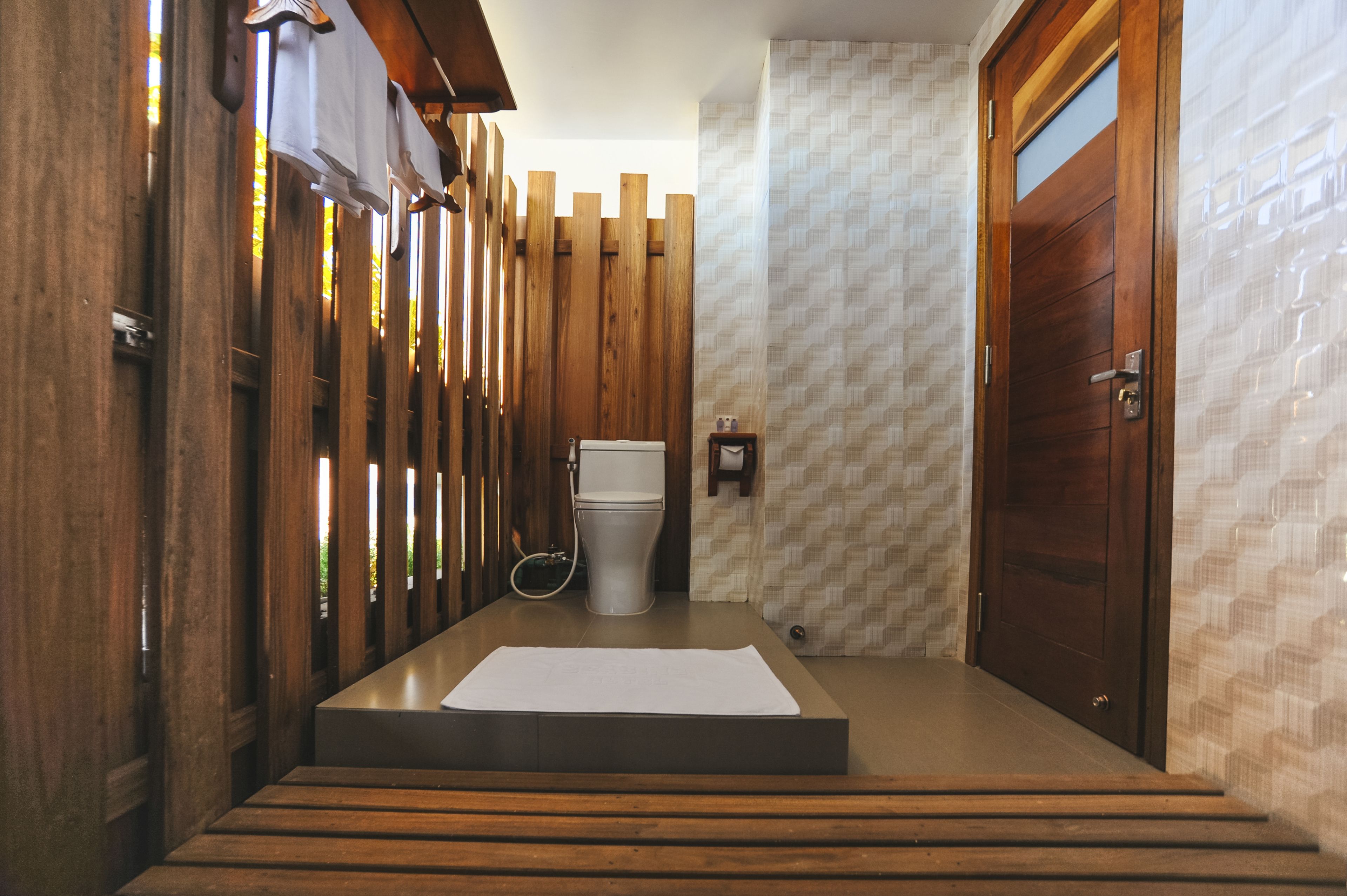 Ein modernes Badezimmer mit Holzwand, Toilette und Waschbecken.