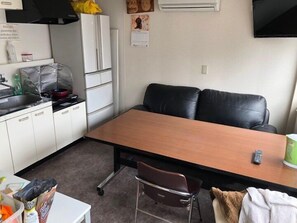 Een koelkast, een magnetron, kookgerei, borden en bestek