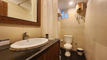 Ein Badezimmer mit Waschbecken, Toilette und Duschbereich.
