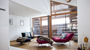 A modern living room with two sofas, a coffee table, and a liquor display. - Alpina Lech Geborgen in den Bergen (Lech am Arlberg)