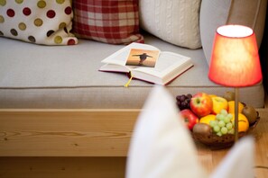 A cozy reading nook with a book, a photo, and a fruit basket on a wooden table.