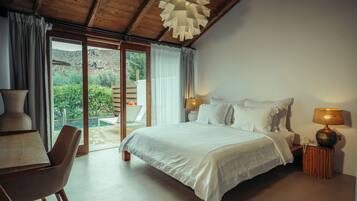 A bedroom with a bed, a desk, a chair, a lamp, and a view of the outdoors.