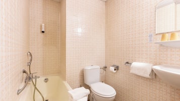 A bathroom with a bathtub, toilet, and sink.