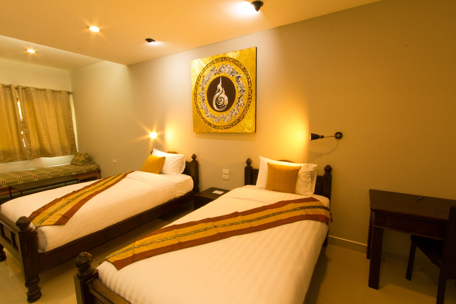 Habitación de hotel con dos camas individuales, un escritorio y una obra de arte colgada en la pared.