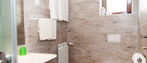 A bathroom with a shower, toilet, and sink.