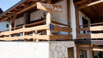 A wooden balcony with a sign reading "PLITVICA Lodge".