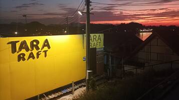 Un edificio amarillo con la inscripción "TARA RAFT", cerca de las vías del tren.