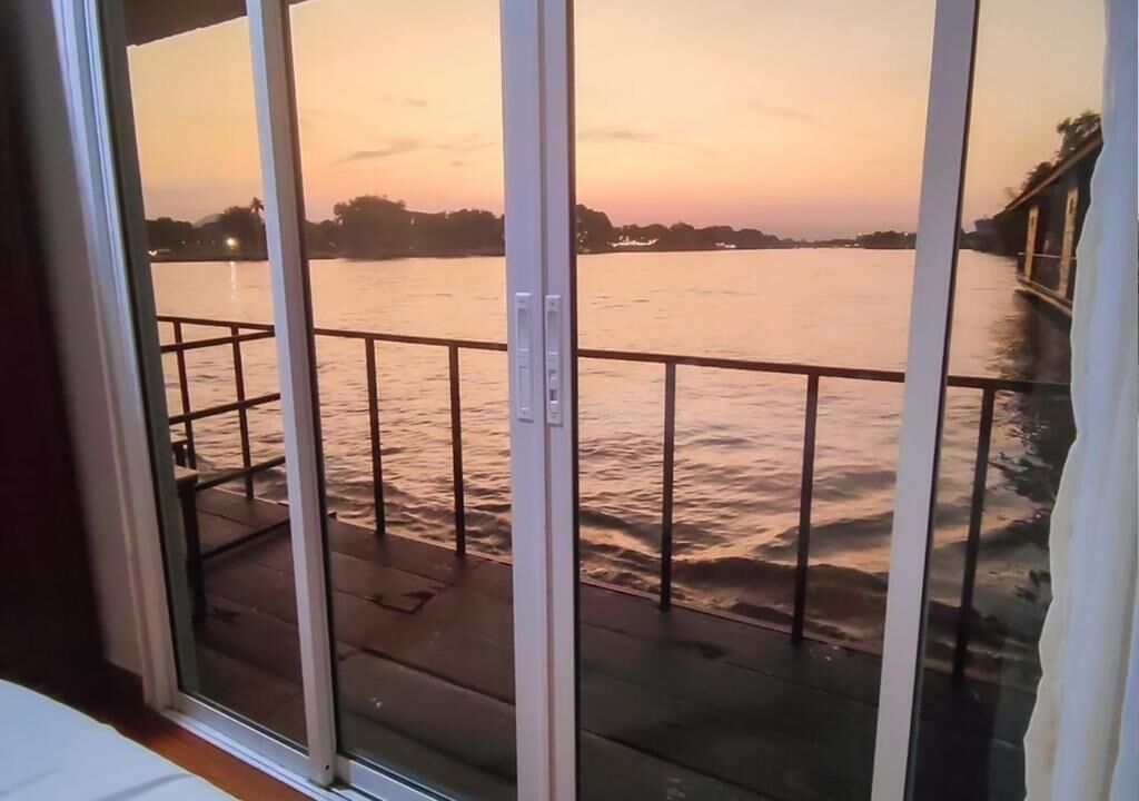 A view from a balcony overlooking a body of water during sunset.