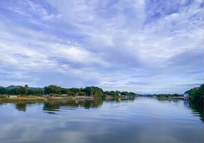 A calm river with a bridge and buildings on the banks. - Tara Raft Kanchanaburi (Kanchanaburi)