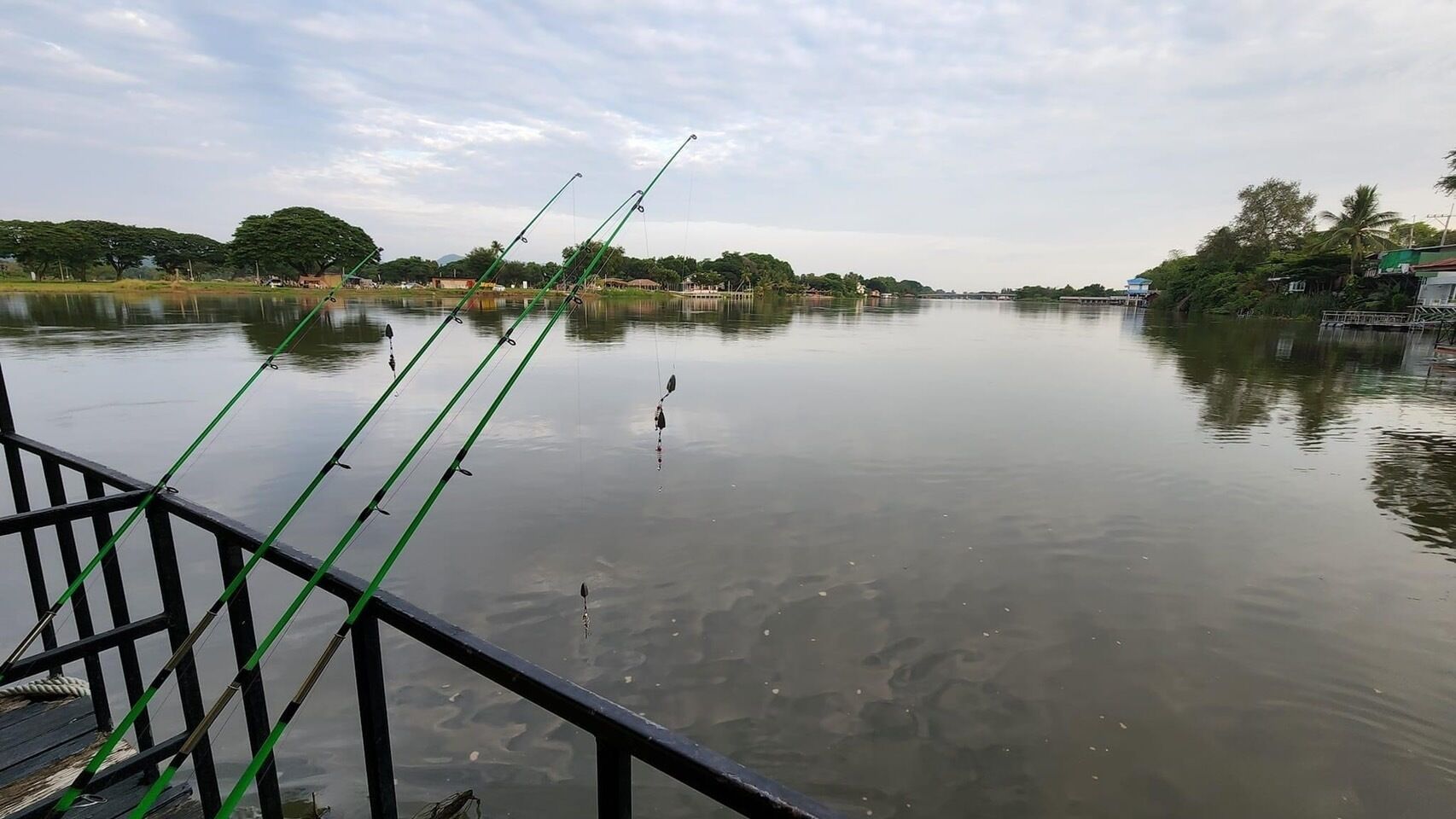 Un lago tranquilo con cañas de pescar en un muelle.