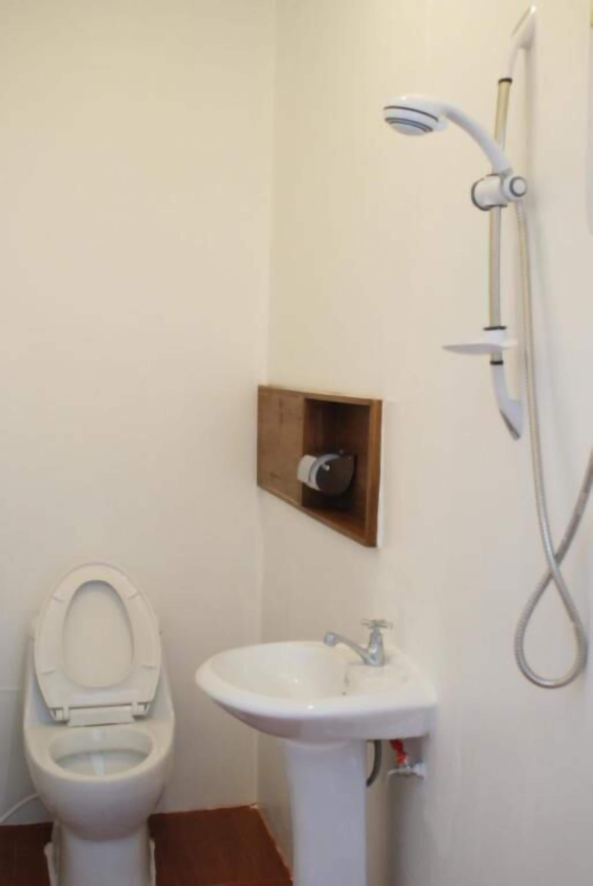 A bathroom with a toilet, sink, and shower.