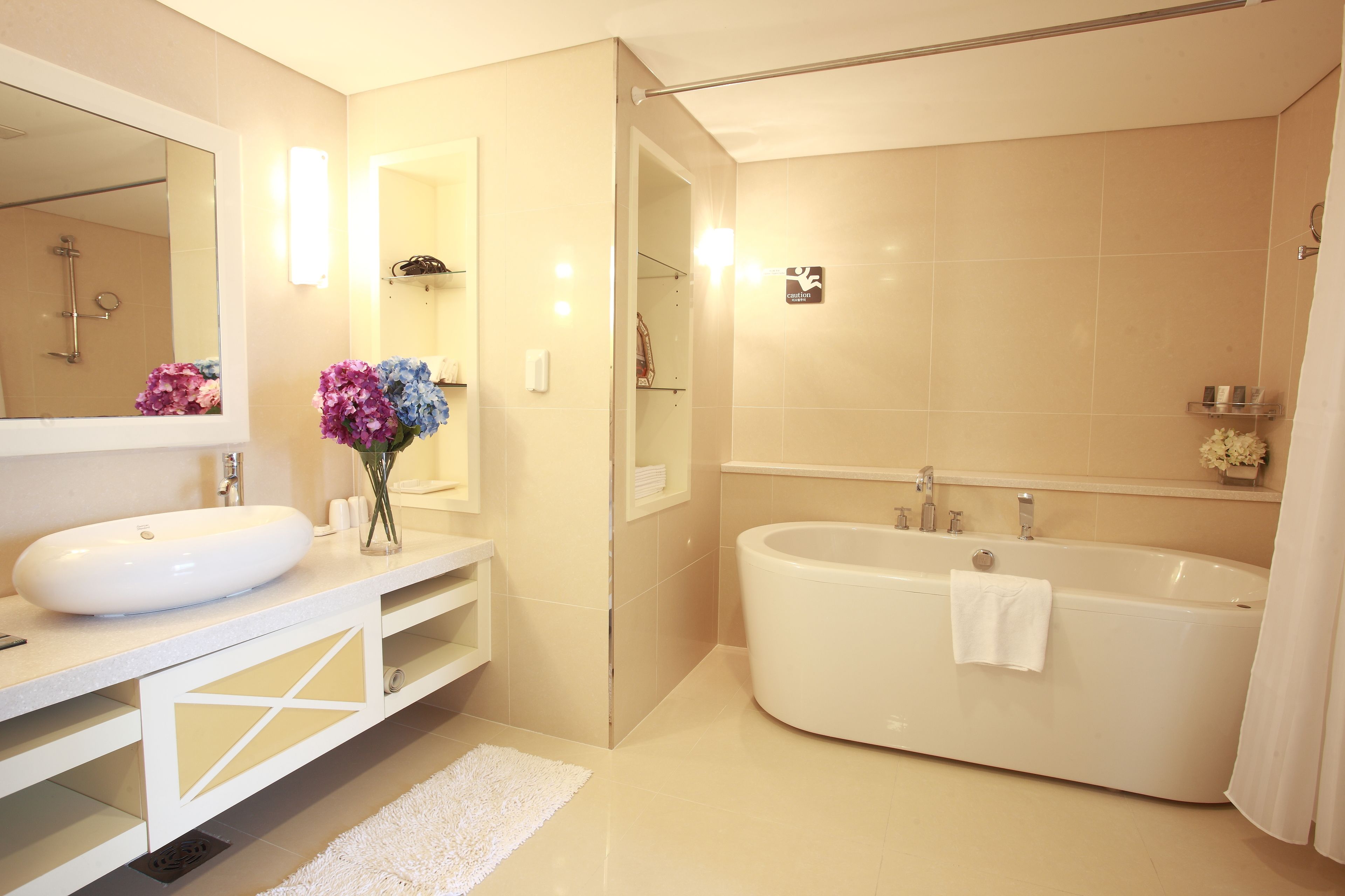 Une salle de bain moderne avec une grande baignoire, un meuble-lavabo à deux vasques et un miroir.