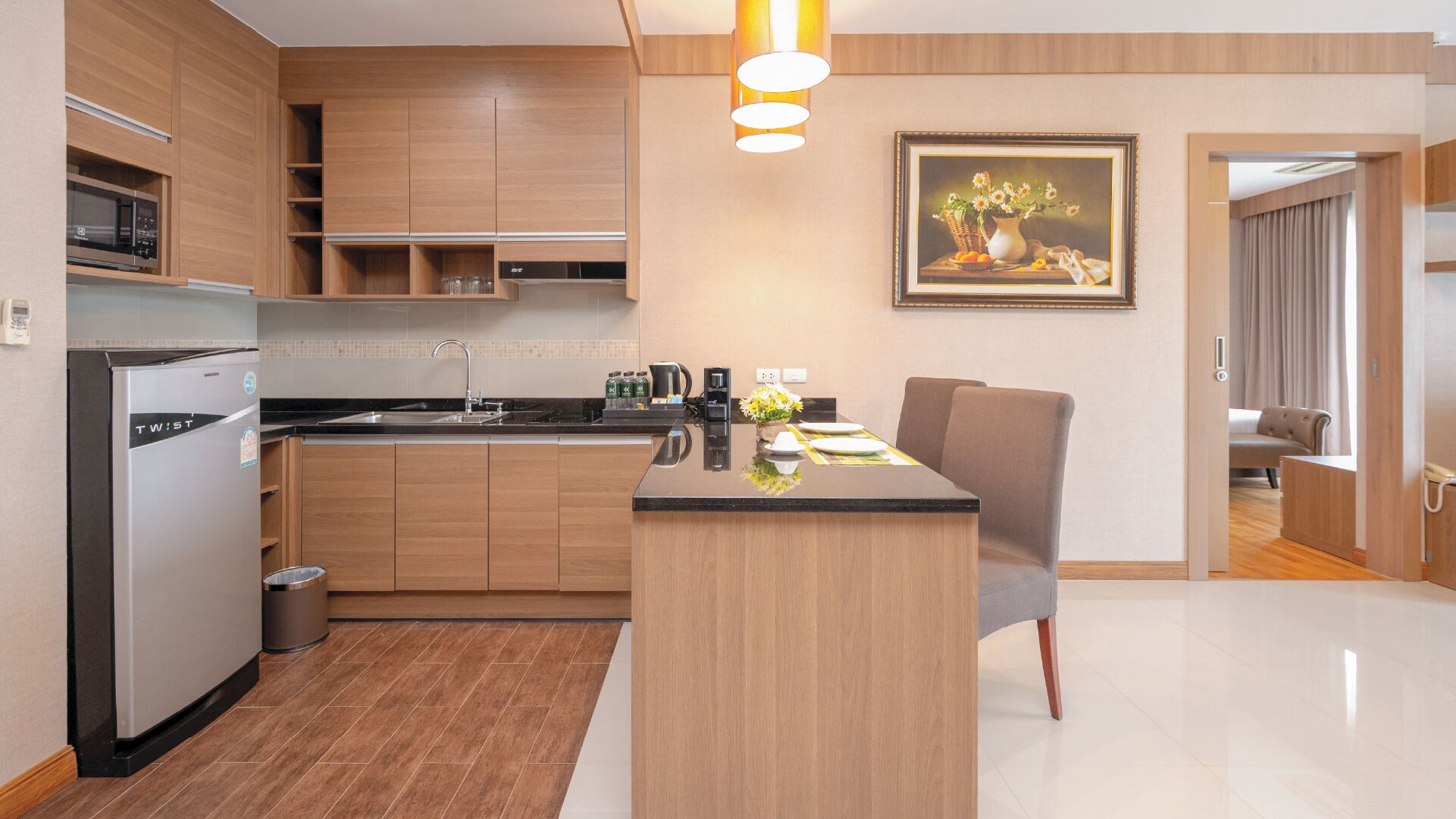 A modern kitchen with a built-in microwave, a coffee maker, and a dining area with a table and chairs.