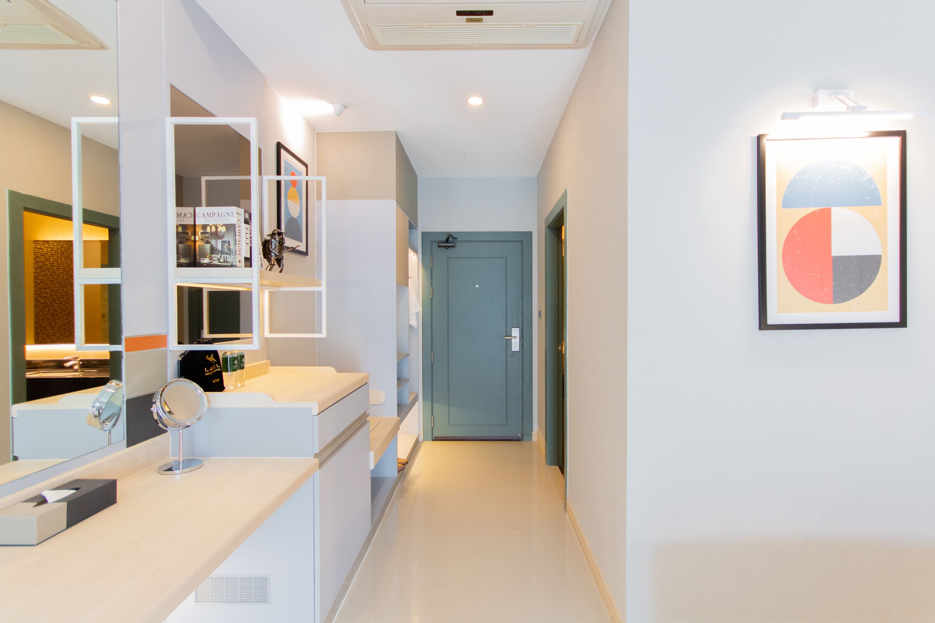 A modern bathroom with a large mirror, a sink, and a door leading to another room.