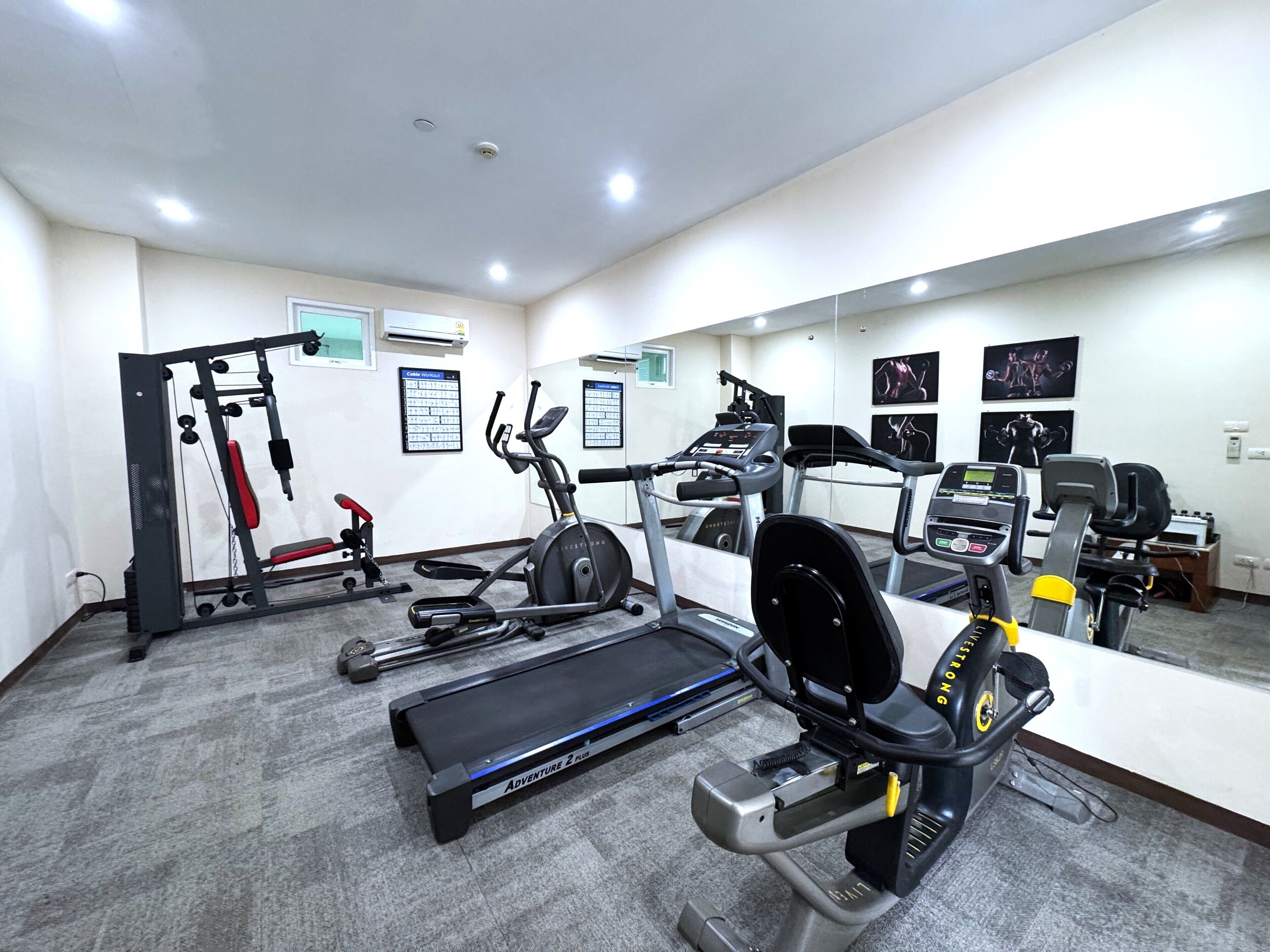 A gym with treadmills, elliptical machines, and weightlifting equipment.