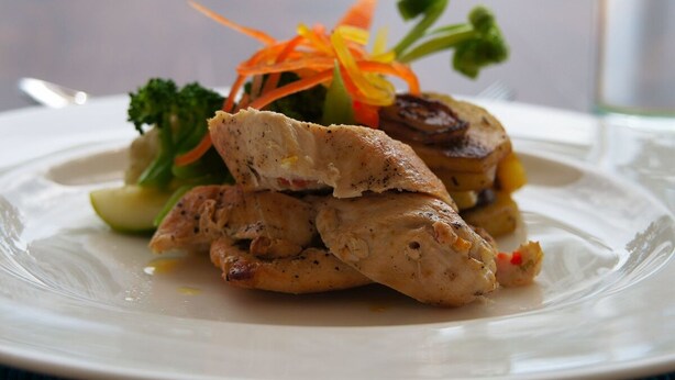A plate of food with chicken, vegetables, and a decorative garnish. - Niyagama House (Galle)