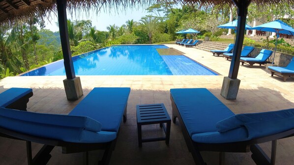 A pool area with lounge chairs and umbrellas.