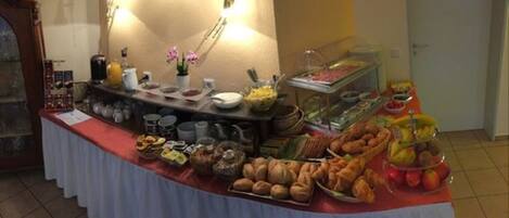 Una mesa de buffet con diversos alimentos y bebidas.