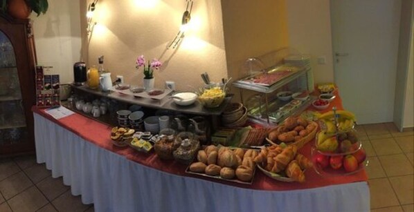 A buffet table with various food items and beverages.
