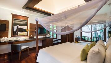 Ein Schlafzimmer mit einem Himmelbett, einem Schreibtisch, einem Stuhl und Blick ins Freie.