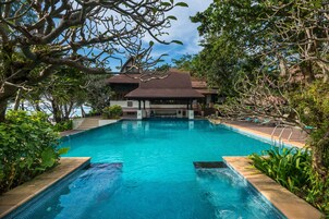 Una piscina al aire libre, sombrillas, tumbonas