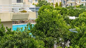 A rooftop pool area with a view of the surrounding buildings and greenery.
