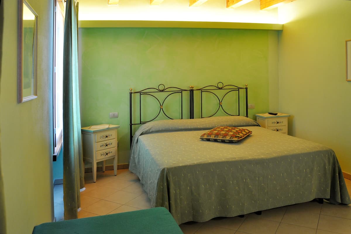 A bedroom with a bed, bedside tables, a dresser, and a mirror.