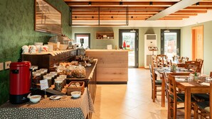 A breakfast buffet with various food items and a coffee maker.